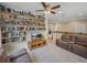 Open living area featuring bookshelves, ceiling fan, and cozy seating arrangement at 8916 Arabella Ln, Seminole, FL 33777