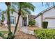 Welcoming front entry with a curved walkway and tropical landscaping at 2217 Platinum Dr, Sun City Center, FL 33573