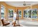 Bright art studio with large windows, an easel, and a comfortable chair at 3921 Mimosa Pl, Palm Harbor, FL 34685