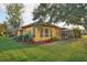 Single-story house with red tile roof, yellow walls and landscaped yard at 3921 Mimosa Pl, Palm Harbor, FL 34685