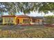 Single-story house with red tile roof, yellow walls and landscaped yard at 3921 Mimosa Pl, Palm Harbor, FL 34685