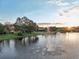 Stunning lakefront property with a fountain at sunset at 3921 Mimosa Pl, Palm Harbor, FL 34685