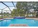 Inviting screened pool with tiled spa and lake view at 3921 Mimosa Pl, Palm Harbor, FL 34685