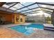 Inviting screened pool with tiled spa and lake view at 3921 Mimosa Pl, Palm Harbor, FL 34685