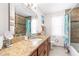 Bathroom with granite countertop, large mirror and tub shower combo at 5592 Fairway Dr, Ridge Manor, FL 33523