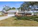 Brick house with a two-car garage and a landscaped yard at 5592 Fairway Dr, Ridge Manor, FL 33523