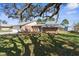Brick house with a two-car garage and a large oak tree at 5592 Fairway Dr, Ridge Manor, FL 33523