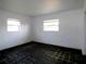 Simple bedroom with dark tile flooring and two windows at 7010 Boca Ciega Dr, St Pete Beach, FL 33706