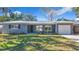 Newly renovated home with a gray exterior, two-car garage, and landscaped lawn at 908 Normandy Rd, Clearwater, FL 33764