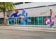 Commercial building featuring glass windows, colorful mural art, and exterior tree at 102 S Moody Ave # 3, Tampa, FL 33609