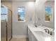 Bathroom with double vanity, white countertops, undermount sinks, and tiled shower at 12241 Meditation Trl, Venice, FL 34293