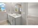 Bathroom with double vanity, white countertops, undermount sinks, and large mirror at 12241 Meditation Trl, Venice, FL 34293