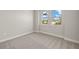 This bedroom features neutral carpet and paint, bright natural light at 12241 Meditation Trl, Venice, FL 34293