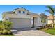 Charming single-story home featuring a gray tiled roof, a two-car garage, and neatly landscaped grounds at 12241 Meditation Trl, Venice, FL 34293