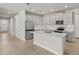 Modern kitchen features white cabinets, quartz countertops, stainless steel appliances, and an island at 12241 Meditation Trl, Venice, FL 34293
