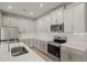 Modern kitchen with white cabinets, stainless steel appliances, and ample counter space at 12241 Meditation Trl, Venice, FL 34293