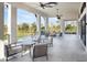 Covered outdoor lounge area with comfortable seating and views of the green space at 12241 Meditation Trl, Venice, FL 34293