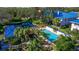 Community pool and pond with lush landscaping and a relaxing patio area at 1688 Watermark Ne Cir # 1688, St Petersburg, FL 33702