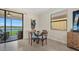 Small dining area with glass table and four blue chairs near a water view at 23503 Waverly Cir, Venice, FL 34293