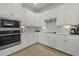 White kitchen with stainless steel appliances and upgraded backsplash at 23503 Waverly Cir, Venice, FL 34293
