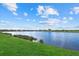 Scenic view of a lake with lush green grass and homes in the background at 23503 Waverly Cir, Venice, FL 34293
