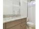This bathroom features a full vanity, a toilet, bright light and a shower-tub combination behind a light shower curtain at 4383 Ortona Ln, Wesley Chapel, FL 33543
