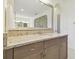 Bathroom vanity with light countertops, dual sinks, wood cabinets and a large mirror reflecting an accent wall at 4383 Ortona Ln, Wesley Chapel, FL 33543