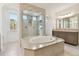 Luxurious bathroom with a large soaking tub, a glass-enclosed shower, and dual vanities at 4383 Ortona Ln, Wesley Chapel, FL 33543