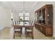 Spacious dining room featuring a wood table, seating for eight, and a large china cabinet at 4383 Ortona Ln, Wesley Chapel, FL 33543