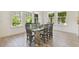 Inviting dining room with large windows and a glass-top table with modern chairs at 4383 Ortona Ln, Wesley Chapel, FL 33543