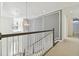 Hallway with decorative wall paneling, carpet flooring, and pendant lights at 4383 Ortona Ln, Wesley Chapel, FL 33543