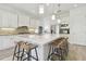 Bright, open kitchen with white cabinets, a large center island, and barstool seating at 4383 Ortona Ln, Wesley Chapel, FL 33543