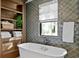 Relaxing bathroom with a freestanding tub and wood shelving at 5104 Homer W Ave, Tampa, FL 33629