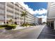 Condo building with a grand entrance, lush landscaping, and parking at 5501 80Th N St # 214, St Petersburg, FL 33709