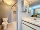 Bathroom features a modern walk-in shower with decorative tile, a toilet, and a vanity with ample lighting at 6262 93Rd N Ter # 3904, Pinellas Park, FL 33782