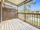 View of the outdoor screened-in porch with wood flooring and a scenic view of the pond at 6262 93Rd N Ter # 3904, Pinellas Park, FL 33782