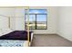 Bright bedroom featuring a canopy bed and a large window overlooking the serene lake view at 9132 Bernini Pl, Sarasota, FL 34240