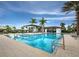 Resort-style community pool with crystal-clear water, palm trees, and comfortable lounging areas at 9132 Bernini Pl, Sarasota, FL 34240