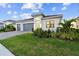Modern single-Gathering home featuring a well-manicured lawn, gray garage doors, and tasteful landscaping at 9132 Bernini Pl, Sarasota, FL 34240