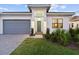 Inviting home exterior featuring a grey garage door, a stylish entrance, and lush green lawn at 9132 Bernini Pl, Sarasota, FL 34240
