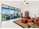 Bright living room with expansive windows offering serene views of the lake and outdoor seating at 9132 Bernini Pl, Sarasota, FL 34240