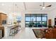 Open-concept living space with lake views, a modern kitchen, and access to the patio at 9132 Bernini Pl, Sarasota, FL 34240