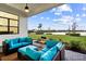 Cozy outdoor patio featuring comfortable seating and serene views of the lush backyard and lake at 9132 Bernini Pl, Sarasota, FL 34240