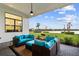 Inviting covered patio featuring comfortable wicker seating with stunning views of the lake at 9132 Bernini Pl, Sarasota, FL 34240