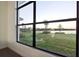 Expansive window offering stunning views of the lake and lush greenery from inside the home at 9132 Bernini Pl, Sarasota, FL 34240