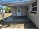 A covered back porch featuring access to the backyard and the home through a door with glass panes at 11608 Zimmerman Rd, Port Richey, FL 34668