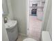 Well-lit half-bath with gray vanity and tiled floors; view to kitchen at 11608 Zimmerman Rd, Port Richey, FL 34668