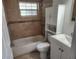 Clean bathroom with a tub, toilet, vanity and white storage cabinet at 11608 Zimmerman Rd, Port Richey, FL 34668