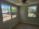Well-lit bedroom featuring neutral walls, tile flooring, and a ceiling fan at 11608 Zimmerman Rd, Port Richey, FL 34668