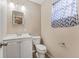 Simple bathroom with a white vanity, toilet, and a window with patterned curtain at 1742 31St S St, St Petersburg, FL 33712